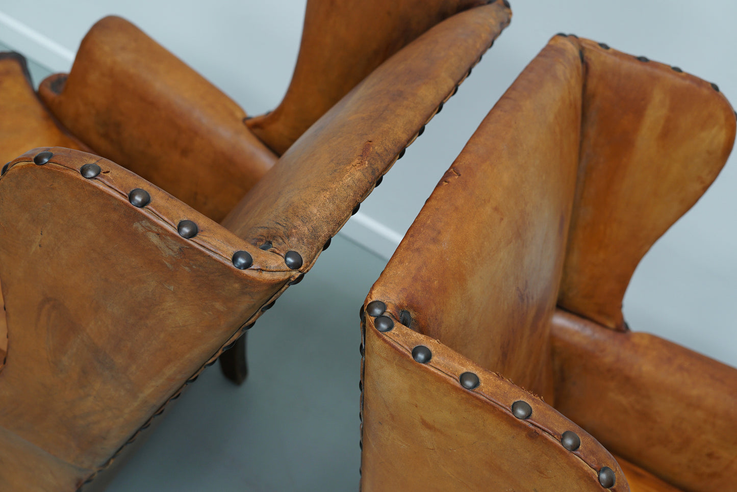 Pair of Patinated Dutch Wingback Cognac Colored Leather Club Chairs
