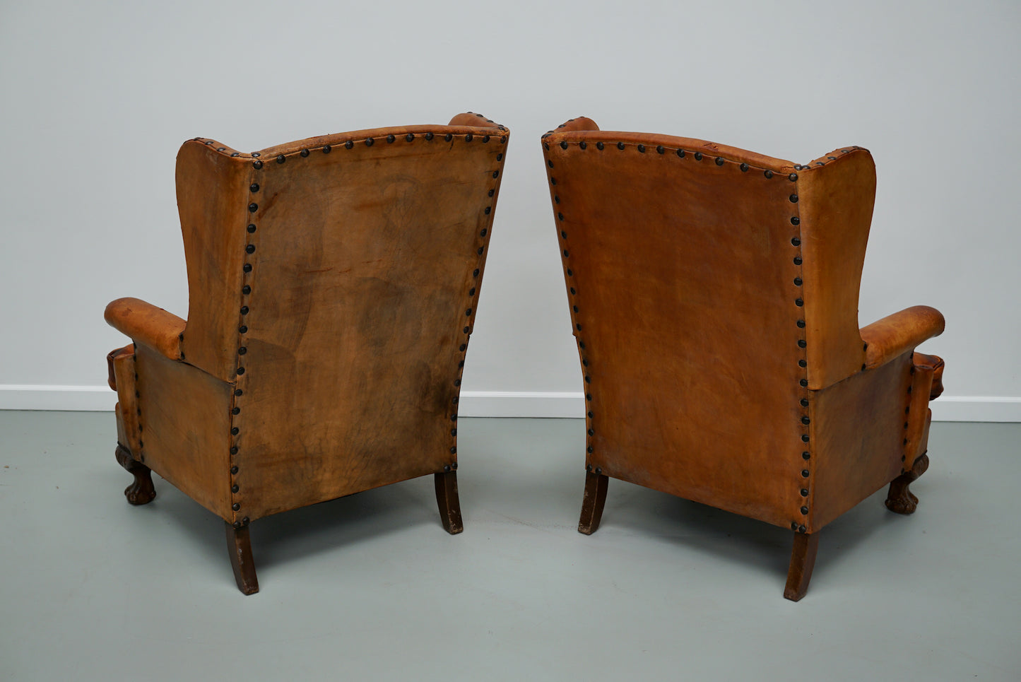 Pair of Patinated Dutch Wingback Cognac Colored Leather Club Chairs
