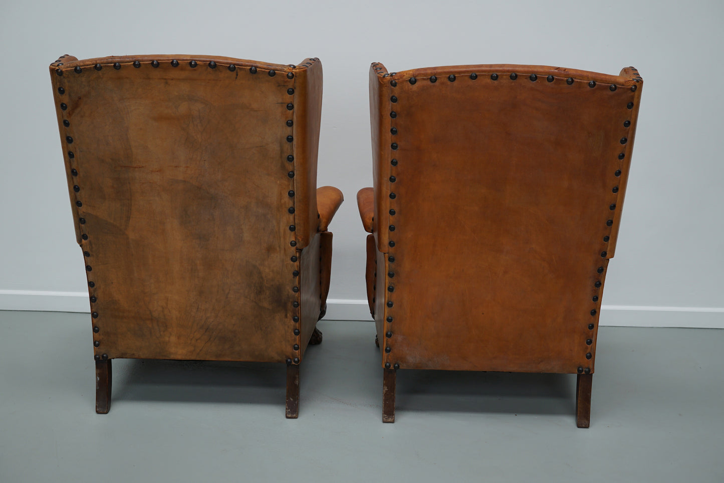 Pair of Patinated Dutch Wingback Cognac Colored Leather Club Chairs