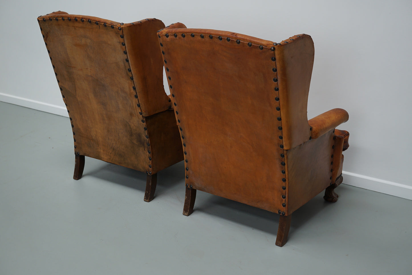 Pair of Patinated Dutch Wingback Cognac Colored Leather Club Chairs